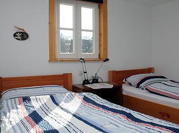 SCHLAFZIMMER 2 im Obergeschoss des Hauses, ausgestattet mit 2 Einzelbetten, Leuchte, Stuhl und Kommode. Zur Vergrerung anklicken!